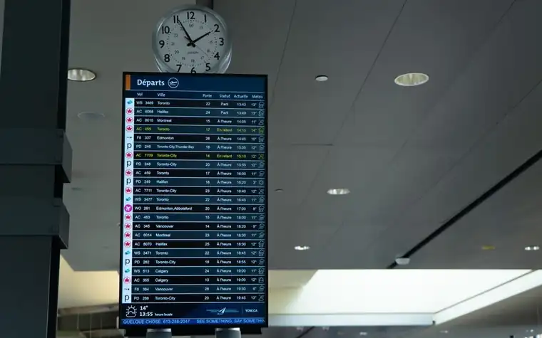 공항 대합실 시계 아래 놓인 출발 안내 전광판
