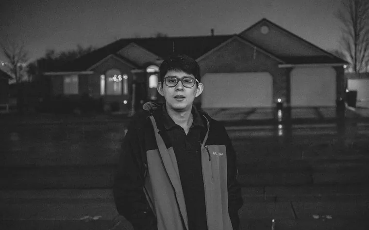거리에 서서 서류를 든 사람의 흑백 사진