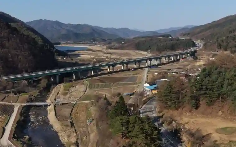산과 강 사이 도로 다리가 놓인 농촌 계곡을 내려다본 모습