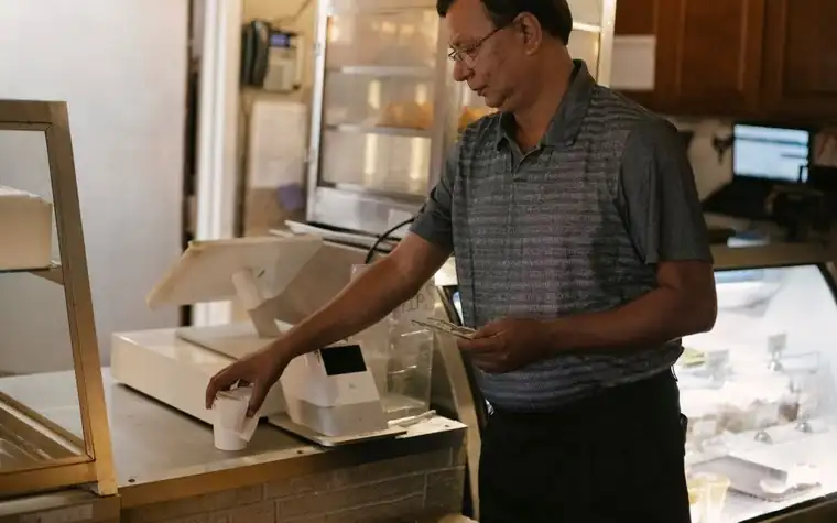 가게 계산대에서 결제 단말기를 다루는 점원